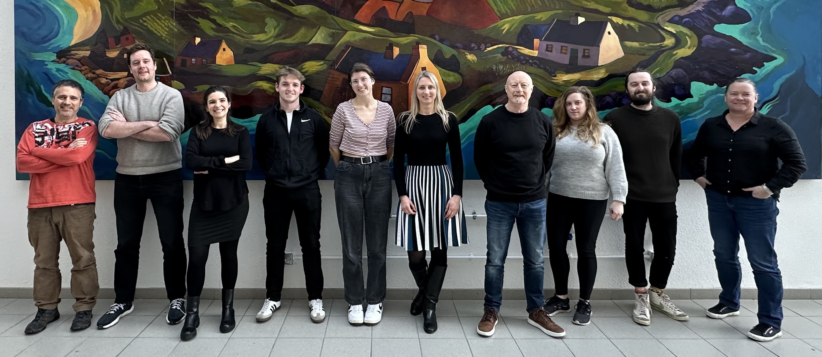 Group of people standing in front of a large painting